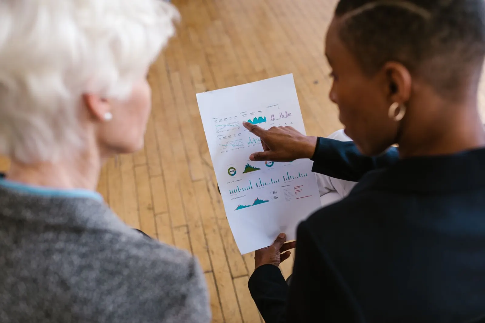 Masa üzerinde yan yana duran iki rapor ve not alınmış bir dosya.